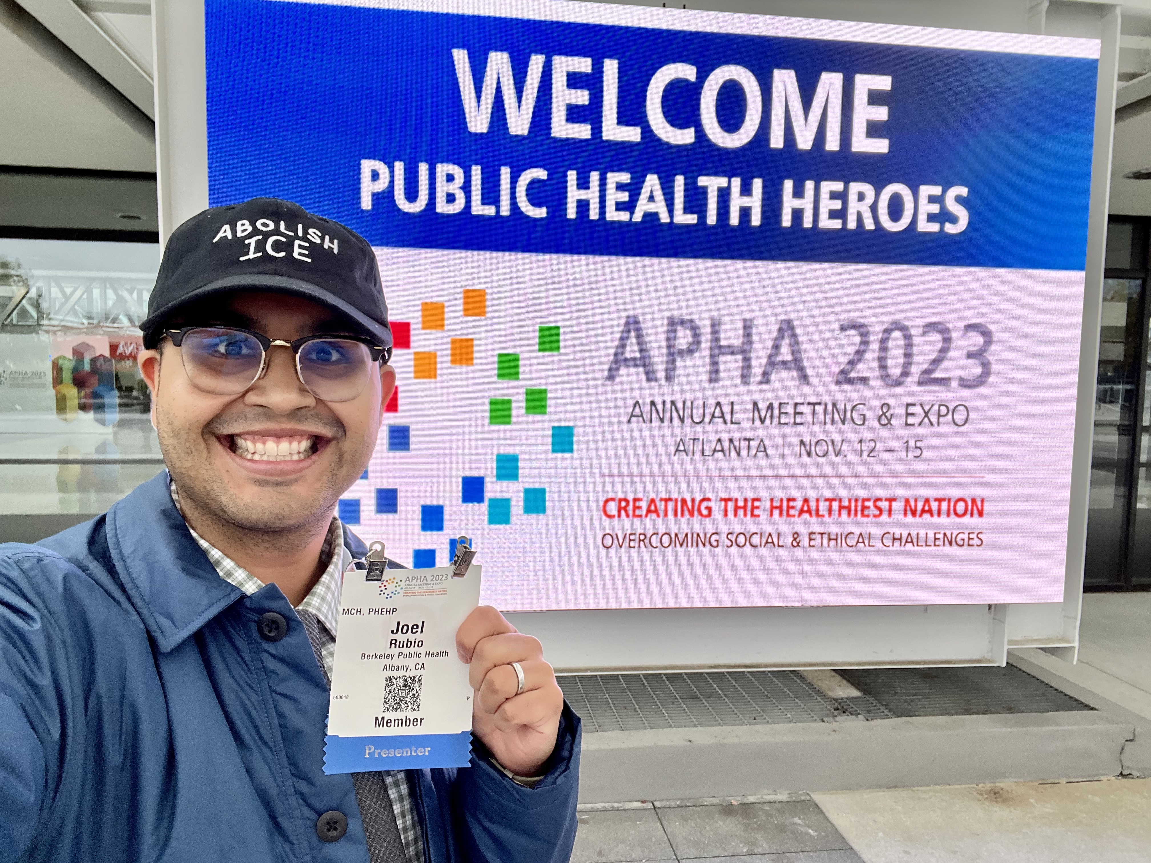 Joel Rubio standing in front of the Welcome sign at APHA