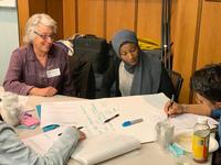 students and faculty work together at a table.