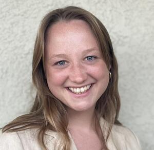 Headshot of Chloe Hood wearing a tan blazer.