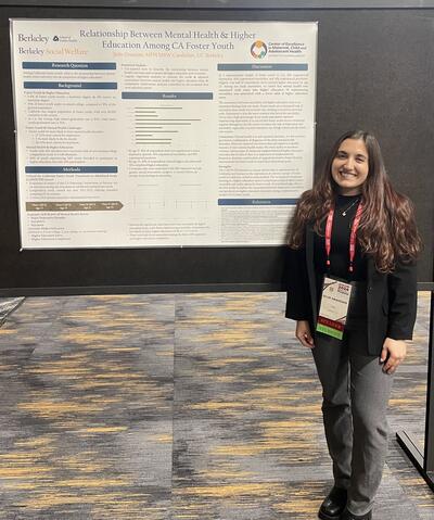 Julie Grassian standing in front of her poster at AMCHP. It is titled "Relationship Between Mental Health & Higher Education Among CA Foster Youth"