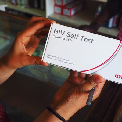 Hands hold a box containing an HIV self test.